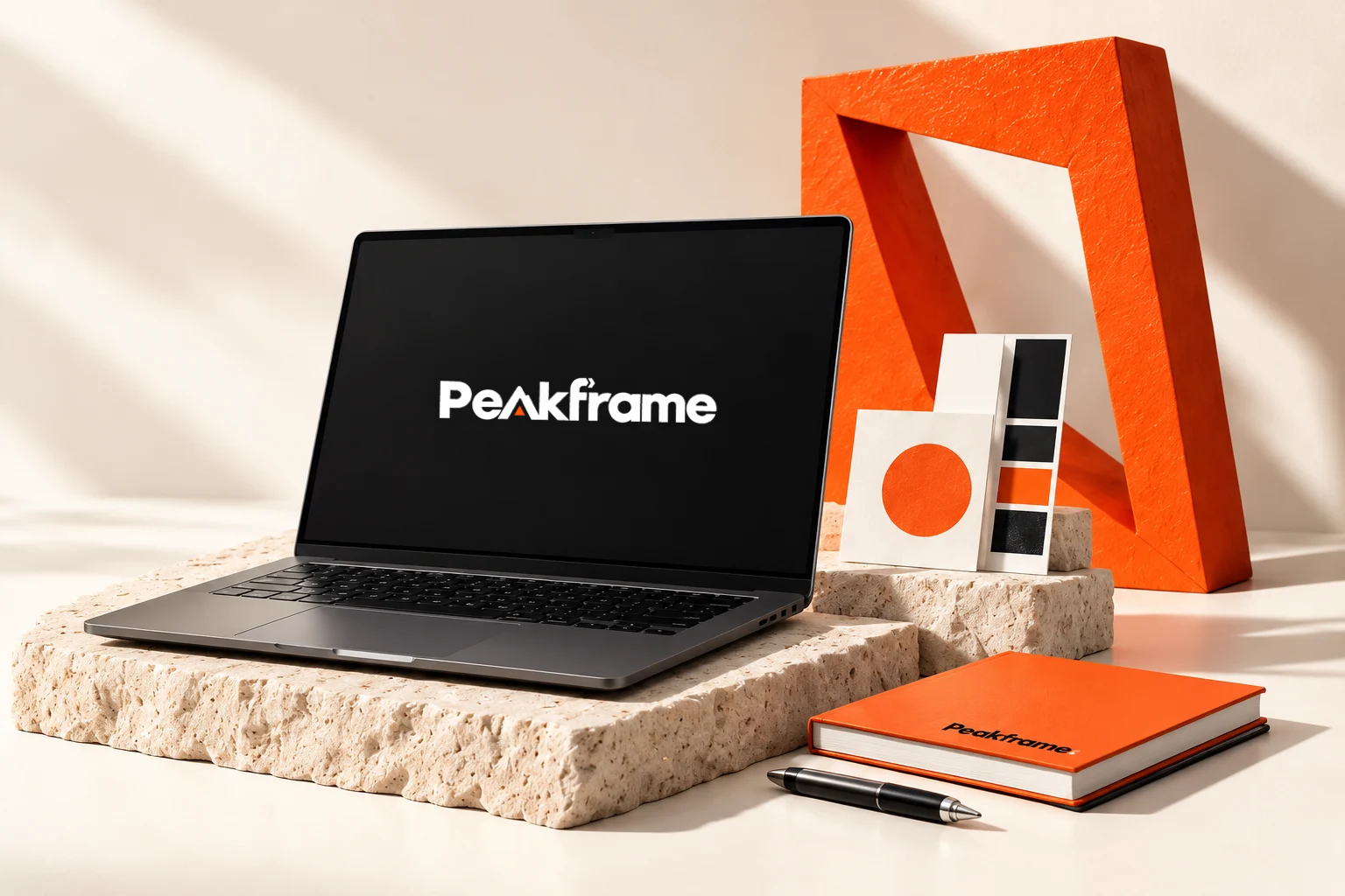 Peak Frame studio concept with laptop, orange frame, notebook and colour swatches